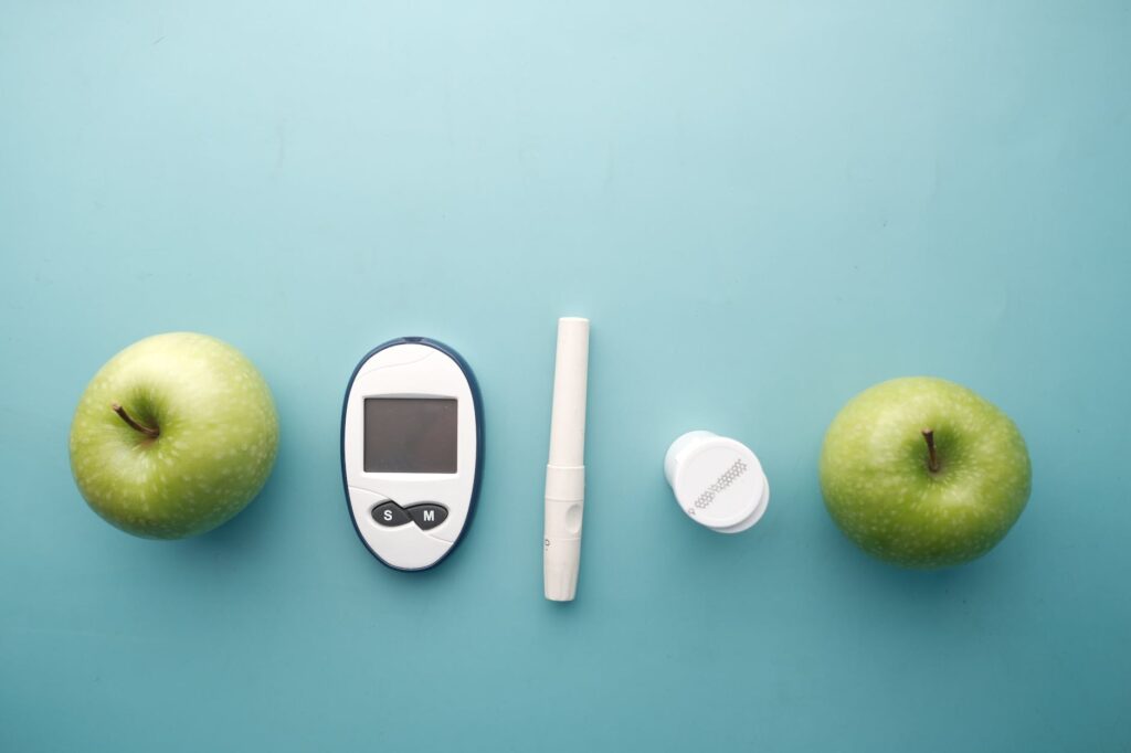 Free and Easy to Follow Pre-Diabetes Treatment from Dr J.V. Dixit | blood glucose meter kit between green apples
