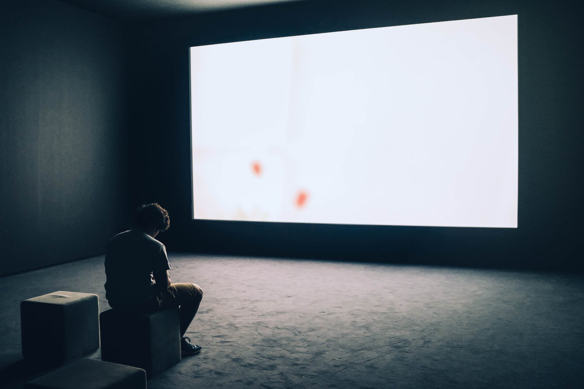 man sitting in front of turned on screen, Poem: Waiting For Something | Photo by Adrien Olichon on Pexels.com