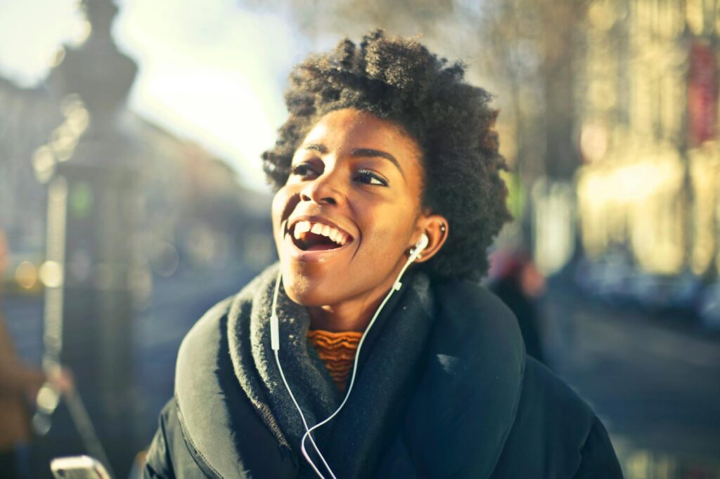 close up photo of a woman listening to music: n a world full of noise, true listening is rare. Discover why being present and truly hearing someone is the most radical act of love left today.