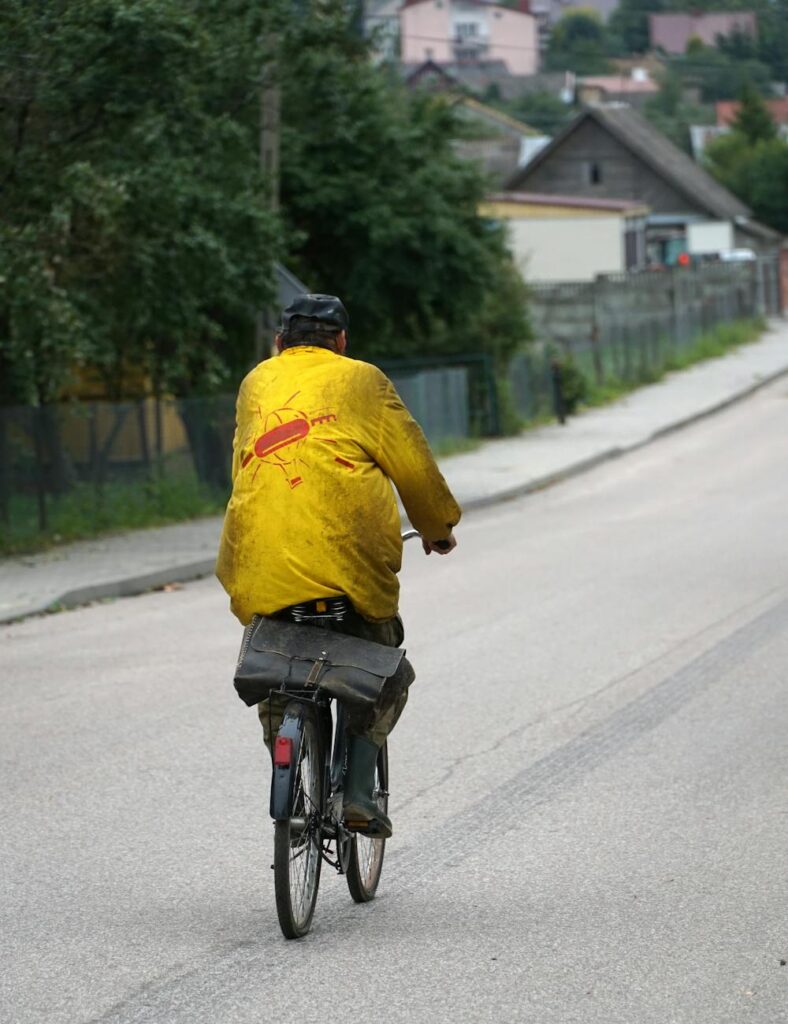 a man in a yellow jacket riding a bike