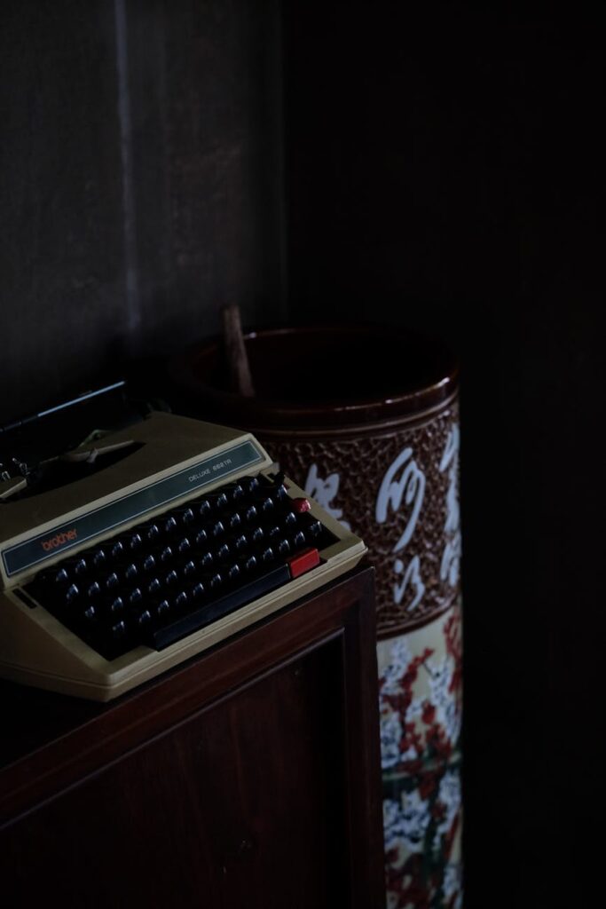 vintage typewriter in dimly lit room: As AI tools evolve, many writers are wondering: “Why does this sound like me?” A quiet, honest look at authorship, consent, and creativity.