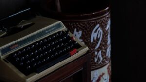 vintage typewriter in dimly lit room: As AI tools evolve, many writers are wondering: “Why does this sound like me?” A quiet, honest look at authorship, consent, and creativity.