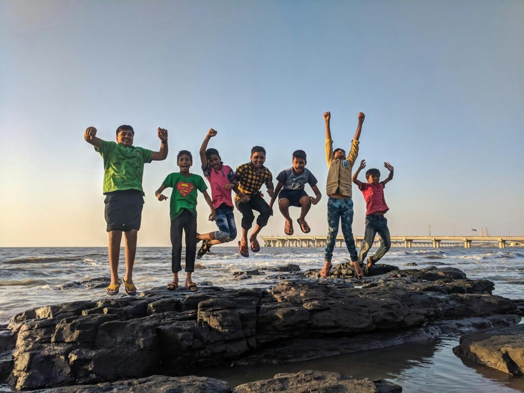 Ignite young minds, inspire innovation, and lead with higher thinking—discover how visionary habits and disruptive ideas shape tomorrow’s industrial and scientific future : boy wearing green crew neck shirt jumping from black stone on seashore